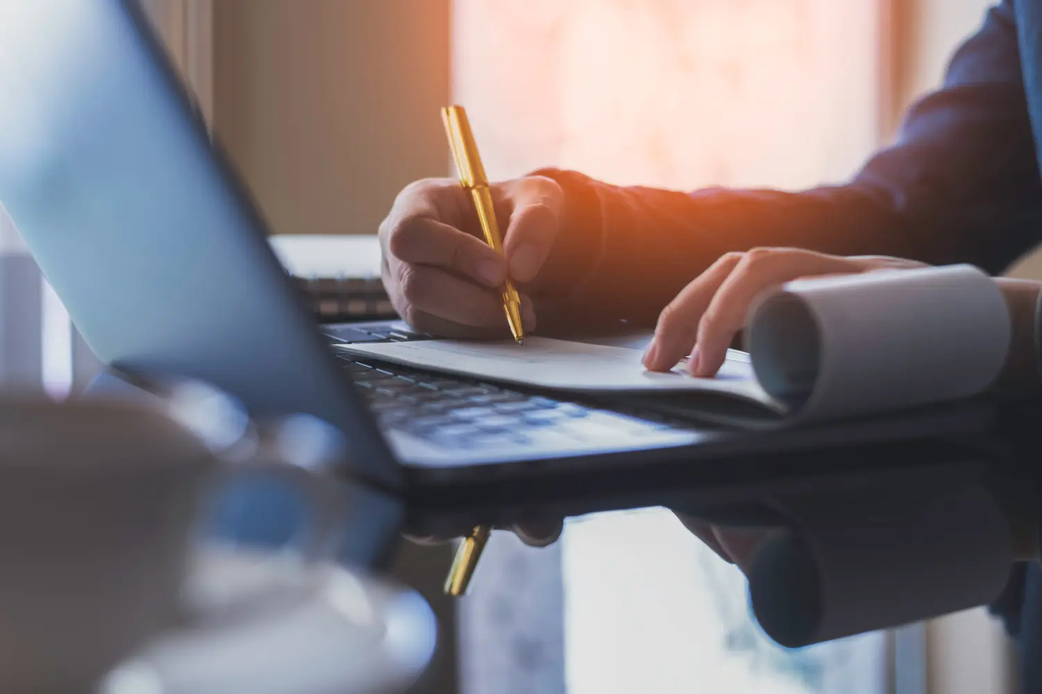 Business-Frau Hand schreiben und unterschreiben Scheckbuch mit Laptop-Computer auf dem Schreibtisch im Büro. Scheck Zahlung, Gehaltsscheck und Gehaltsabrechnung konzeptionelle